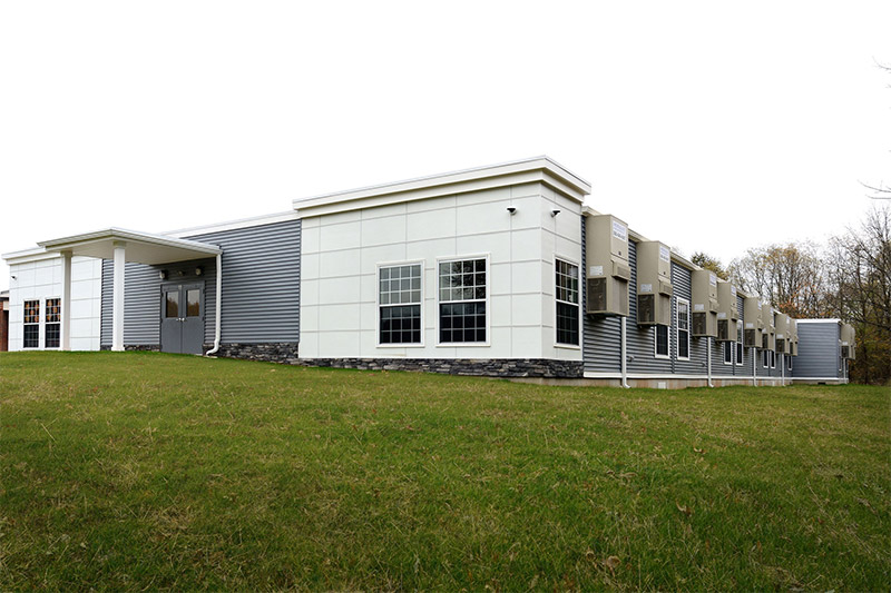 Modular classroom building in Pedricktown, NJ, with a grassy hill in front
